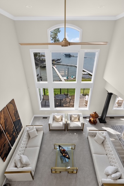 The great room seen from the upper landing, looking down over the seating groups to the lake windows