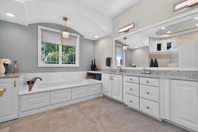 The primary bath with double stone vanity, soaking tub and walk-in shower