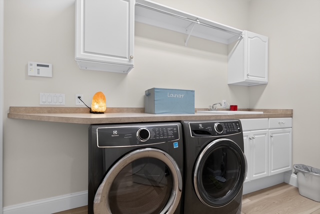 The estate laundry room with full-size washer and dryer and folding counter