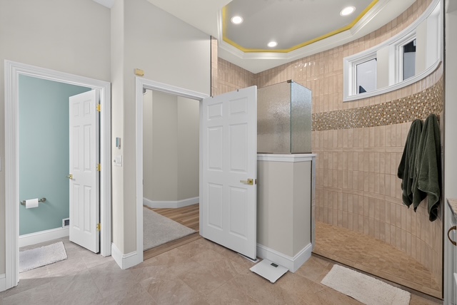 A tiled walk-in shower with mosaic banding beside the suite's private water closet