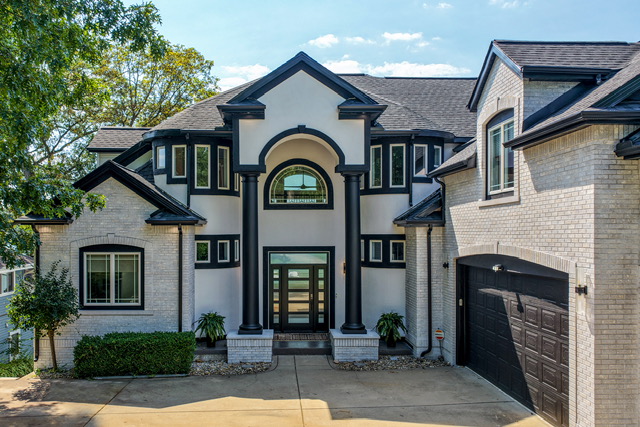 The columned front entry of the estate with arched transom and attached garage